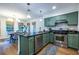 Kitchen with stainless steel appliances, custom green cabinets, and a black countertop island at 1100 Ashbury Dr, Decatur, GA 30030