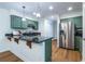 Kitchen featuring custom green cabinets, stainless steel refrigerator, and granite countertops at 1100 Ashbury Dr, Decatur, GA 30030