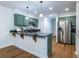 Bright kitchen features green cabinets, stainless steel appliances, hardwood floors and black countertops at 1100 Ashbury Dr, Decatur, GA 30030