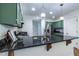 Kitchen with stainless steel appliances, custom green cabinets, and a black countertop island at 1100 Ashbury Dr, Decatur, GA 30030