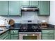 Kitchen featuring custom green cabinets, stainless steel oven, and granite countertops at 1100 Ashbury Dr, Decatur, GA 30030