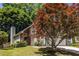 View of side and front of home with brick chimney and an attached two car garage at 1100 Ashbury Dr, Decatur, GA 30030