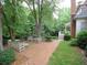 Secluded backyard brick patio with seating areas amidst lush landscaping and mature trees at 1811 Murdock Rd, Marietta, GA 30062