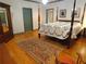 Spacious bedroom featuring a four-poster bed, hardwood floors, and a colorful area rug at 1811 Murdock Rd, Marietta, GA 30062
