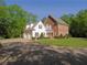 Beautiful brick and siding home with mature trees, lush lawn, a circular driveway, and an attached garage at 1811 Murdock Rd, Marietta, GA 30062