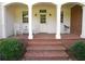 Inviting front porch with white rocking chairs, brick flooring and stairs, with a horse weather vane decoration at 1811 Murdock Rd, Marietta, GA 30062