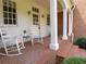 Front porch with classic columns, white rocking chairs, and brick steps offers a relaxing outdoor space at 1811 Murdock Rd, Marietta, GA 30062