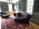 This office features a dark leather chair, hardwood floors and a traditional wooden desk with a fan and books at 1811 Murdock Rd, Marietta, GA 30062
