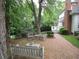 Charming brick patio with wooden furniture, surrounded by lush greenery and a glimpse of the house at 1811 Murdock Rd, Marietta, GA 30062