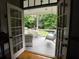 View from French doors opening to porch with wicker furniture, ceiling fan, and swing, overlooking lush greenery at 1811 Murdock Rd, Marietta, GA 30062