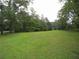 Large grassy yard surrounded by mature trees and vegetation at 1811 Murdock Rd, Marietta, GA 30062