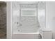This bathtub features marble-look tiles, a small window, and modern fixtures at 2121 Harmony Dr, Canton, GA 30115