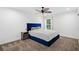Bright bedroom with a blue upholstered headboard, dark nightstand and views to the backyard at 2121 Harmony Dr, Canton, GA 30115