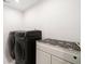 Modern laundry room features front load washer and dryer with folding table at 2121 Harmony Dr, Canton, GA 30115