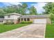 Traditional home featuring a brick exterior, green lawn, mature landscaping and attached garage with long driveway at 3947 Veracruz Ct, Decatur, GA 30034