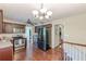 Well-lit kitchen with stainless steel appliances, wood cabinets and floors, and a modern chandelier at 3947 Veracruz Ct, Decatur, GA 30034