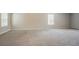 Large room featuring neutral walls and carpeting, with windows offering natural light at 4938 Wewatta Sw St, Atlanta, GA 30331