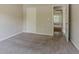 Bedroom features neutral carpeting and a view into an additional room at 4938 Wewatta Sw St, Atlanta, GA 30331