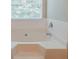 A clean, white bathtub with tile backsplash and a window view at 4938 Wewatta Sw St, Atlanta, GA 30331
