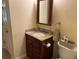 Bathroom vanity featuring dark wood cabinets, granite countertops, and a classic framed mirror at 750 Providence Dr, Lawrenceville, GA 30044