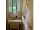 Cozy bathroom vanity area with white cabinets, shuttered window, and built-in storage at 750 Providence Dr, Lawrenceville, GA 30044