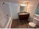Bathroom featuring a shower-tub, dark wood vanity with granite counters, and updated fixtures at 1095 S Burnt Hickory Rd, Douglasville, GA 30134