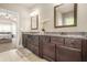 Spacious bathroom with double vanity, granite countertops, dark wood cabinets, and access to the main bedroom at 229 Primstone Way, Mcdonough, GA 30253