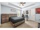 Neutral bedroom with tray ceilings, a ceiling fan and work space with computer desk and gaming chair at 229 Primstone Way, Mcdonough, GA 30253