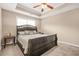 Cozy bedroom features neutral walls, a tray ceiling with a ceiling fan, and plush carpeting at 229 Primstone Way, Mcdonough, GA 30253