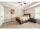 Bedroom features neutral walls, tray ceilings and a ceiling fan; the room is comfortably carpeted at 229 Primstone Way, Mcdonough, GA 30253