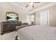 Relaxing bedroom with a tray ceiling and ceiling fan; the room also has an entertainment center with a TV at 229 Primstone Way, Mcdonough, GA 30253