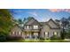 Charming two-story home with a well-manicured lawn, stone accents, and inviting front porch with blue chairs at 229 Primstone Way, Mcdonough, GA 30253