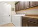 Functional laundry room with washer, dryer, cabinets, and countertop space at 229 Primstone Way, Mcdonough, GA 30253