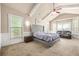 Spacious main bedroom featuring vaulted ceilings, a tufted headboard, and a cozy seating area with large windows at 229 Primstone Way, Mcdonough, GA 30253