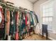 Well-organized walk-in closet maximizes storage with hanging racks and window that provides natural light at 229 Primstone Way, Mcdonough, GA 30253