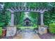 Stone path leads to pergola and outdoor living space with fireplace in lush backyard at 440 Canton Walk, Roswell, GA 30075