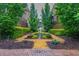 Beautifully landscaped community greenspace with manicured shrubs, mulch and pea gravel paths, and a water feature at 440 Canton Walk, Roswell, GA 30075