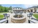 Expansive backyard with a fire pit, lounge chairs, and manicured landscaping for outdoor entertaining at 6301 New Bethany Rd, Buford, GA 30518