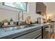 A well-appointed wet bar featuring stainless steel appliances, stone countertops, and a modern faucet at 6301 New Bethany Rd, Buford, GA 30518
