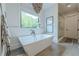 Bright, modern bathroom with a free-standing tub, rainfall shower, and stylish accents at 6301 New Bethany Rd, Buford, GA 30518