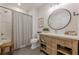 Neutral toned bathroom featuring a wood vanity with marble countertop, tub, and shower at 6301 New Bethany Rd, Buford, GA 30518