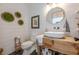 Stylish bathroom featuring shiplap walls, a round mirror, a vessel sink on a wooden vanity, and decorative accents, exuding rustic charm at 6301 New Bethany Rd, Buford, GA 30518