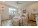 Charming bedroom featuring a canopy bed, ample natural light, and cozy decor, with wood flooring at 6301 New Bethany Rd, Buford, GA 30518