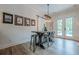 Elegant dining area with a modern table, stylish stools, and decor, illuminated by a unique pendant light, next to a pool view at 6301 New Bethany Rd, Buford, GA 30518