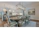Dining room with modern light fixture, seamlessly flowing into the kitchen at 6301 New Bethany Rd, Buford, GA 30518