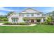 Charming two-story modern farmhouse with a welcoming front porch, black-trimmed windows, and meticulously manicured landscaping at 6301 New Bethany Rd, Buford, GA 30518