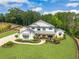 Stunning two-story white home with black trim, a covered porch, lush landscaping, and a long driveway on a large lot at 6301 New Bethany Rd, Buford, GA 30518