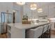 Bright kitchen with large island with seating and modern lighting fixtures at 6301 New Bethany Rd, Buford, GA 30518
