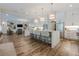 Open-concept kitchen with a large island, stainless steel appliances with adjacent living room at 6301 New Bethany Rd, Buford, GA 30518