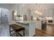 Open kitchen with white cabinets, large island, and modern light fixtures at 6301 New Bethany Rd, Buford, GA 30518